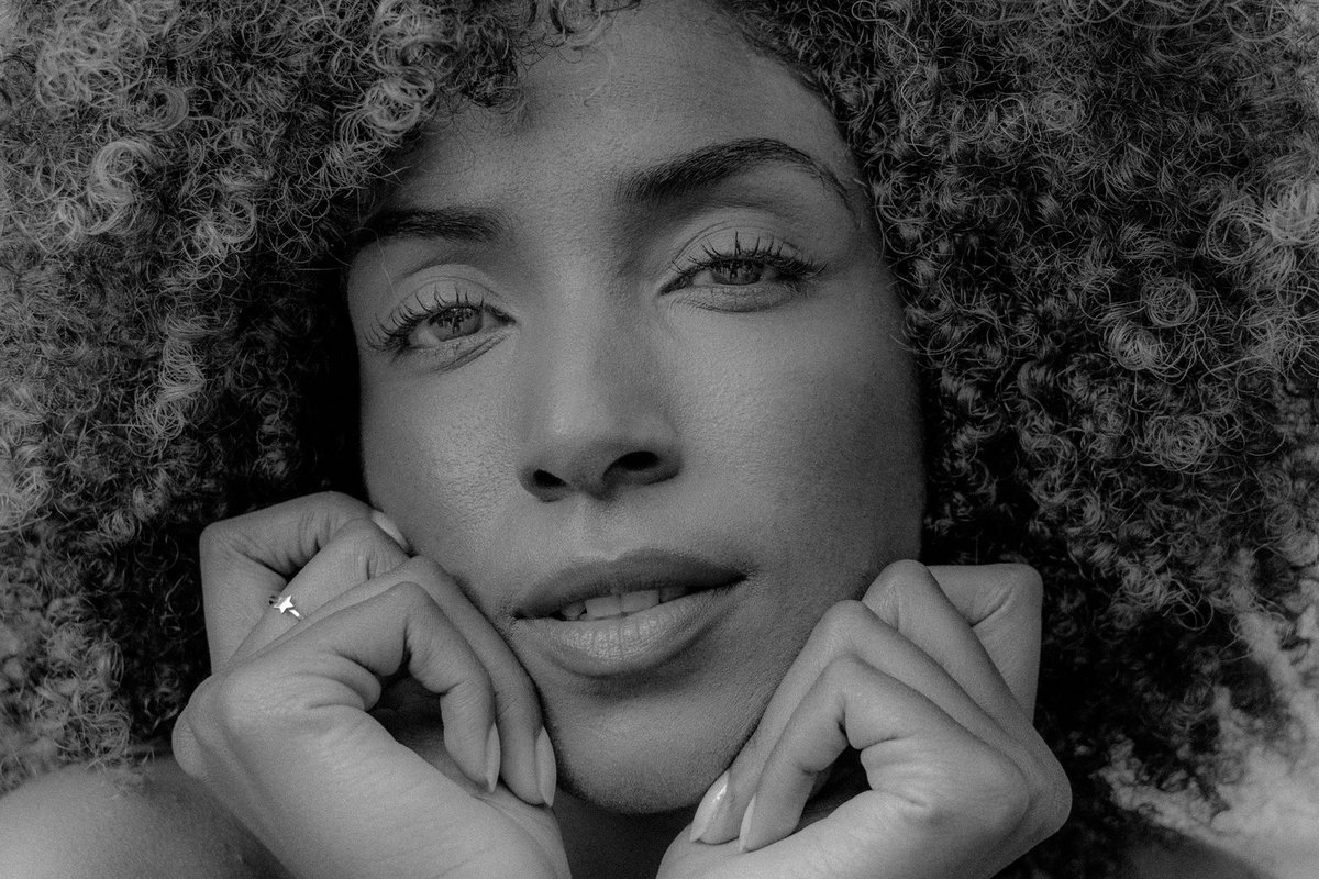 Black and white portrait of a woman with voluminous natural curls framing her face