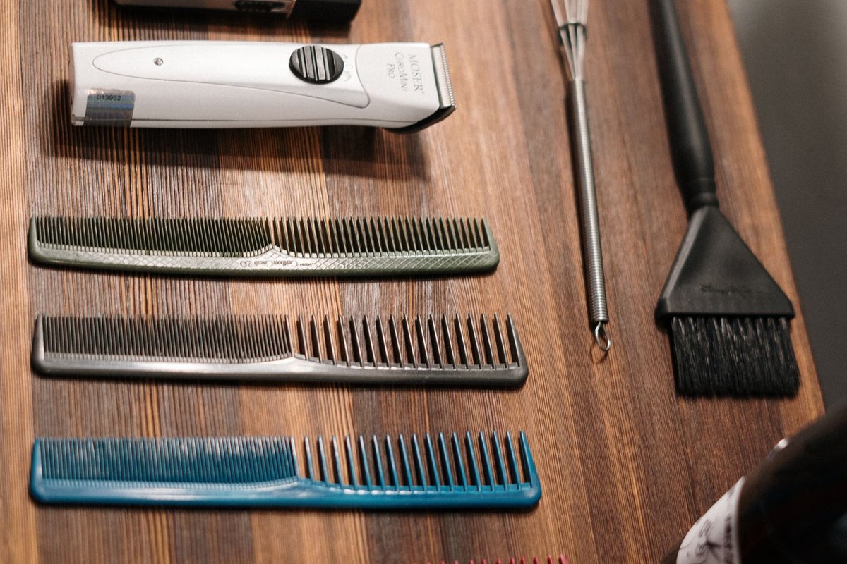 Combs and hairdressing tools laid out on a wooden counter