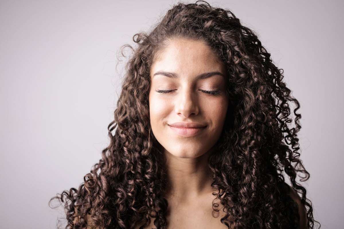 A smiling woman with long natural curls