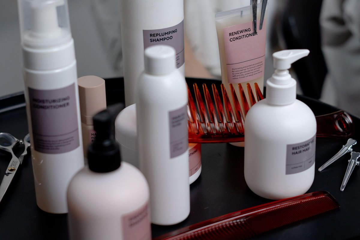 Unbranded shampoo and conditioner bottles on a salon trolley