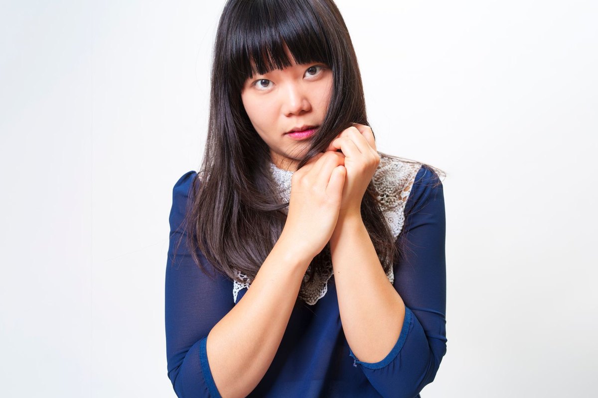 A woman holding the ends of her straight dark hair